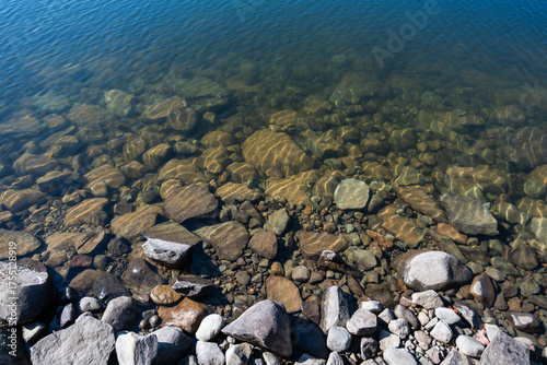 Water shoreline in a reservoir with crystal clear water, rocky coast