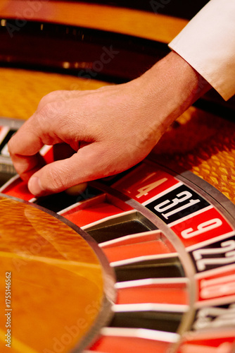 Photography Close-up of roulette wheel and dealer’s hand in casino