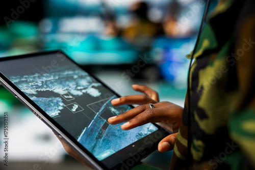 Fotografie Close up of military defense security agent using device to track threats