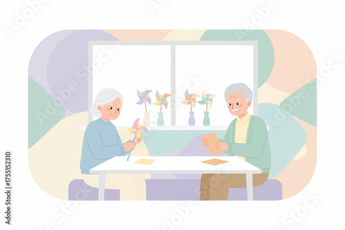 Happy elderly couple making colorful pinwheels enjoying leisure time together