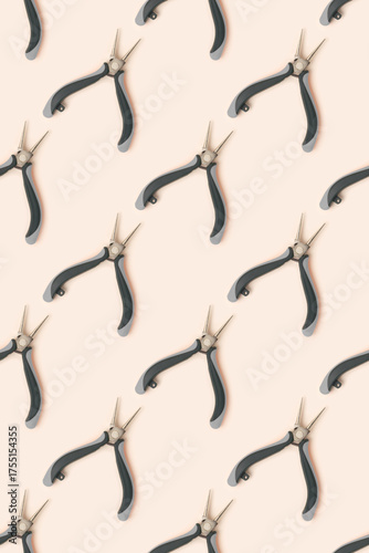 Pattern made of round-nose pliers on a beige background.
