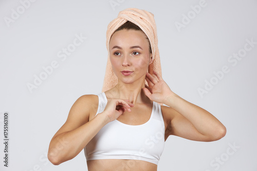 A young beautiful girl in white lingerie with a towel on her head does cosmetic procedures.