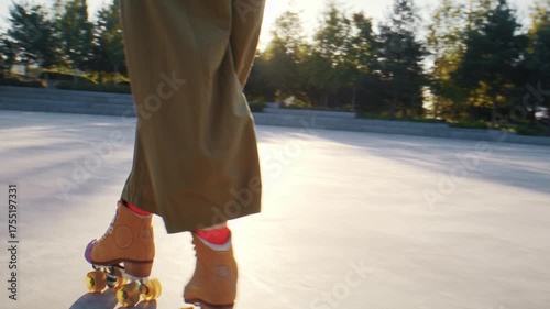 Woman with old fashioned quad skates trains on sports ground