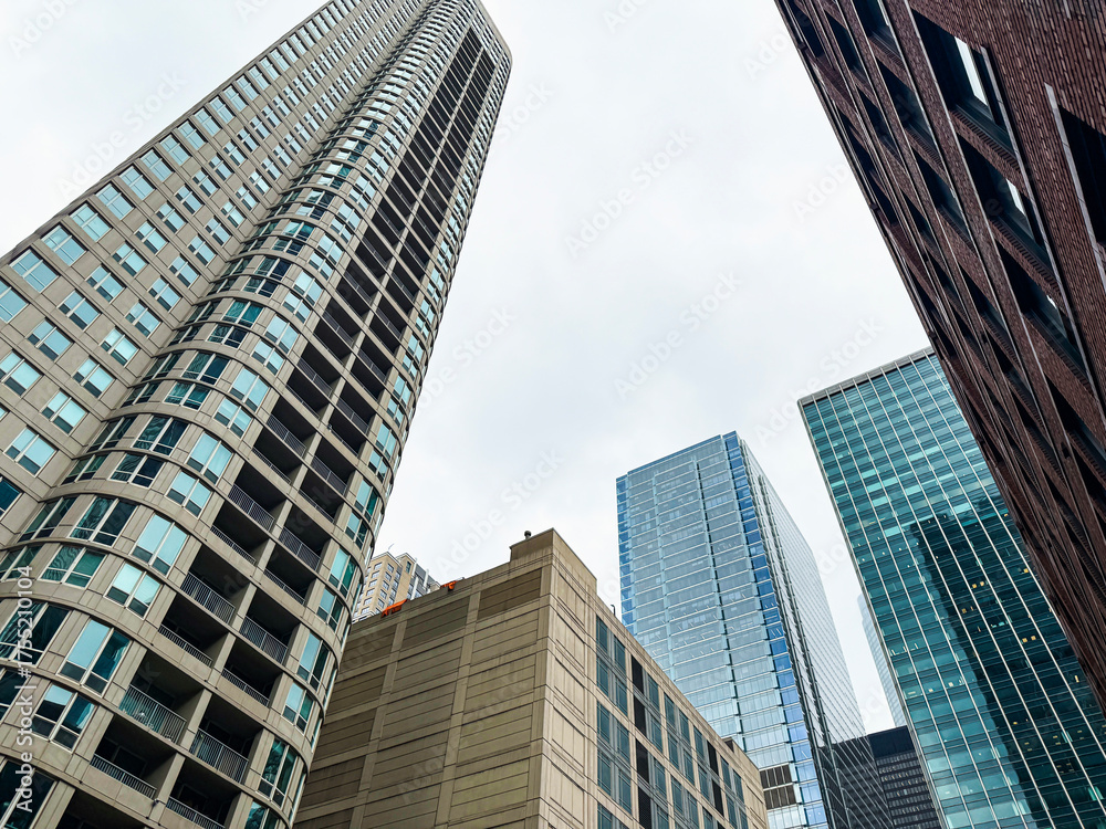 Obraz premium Low angle partial view of skyscraper building architecture in the River North neighborhood of Chicago, Illinois. Set against a soft cloudy sky.