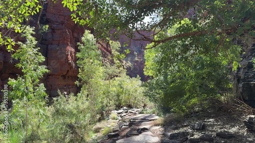 hiking trail through Weano gorge, a popular travel destination inside karijini national park in the outback of Pilbara shire in western Australia, with iconic red cliffs and rock formations.