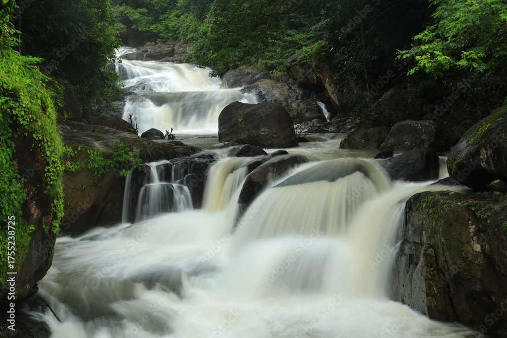 Fototapeta premium Nang Rong waterfall is a multi-tiered waterfall plunges down to several rock formations below, and then flows into the lush surrounding forests ,Nakhon Nayok province ,Thailand 