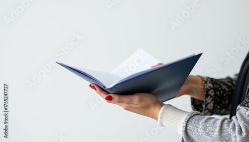 Person is holding open book with blank pages, showcasing moment of curiosity and anticipation. hands are elegantly positioned, emphasizing book importance in this serene setting