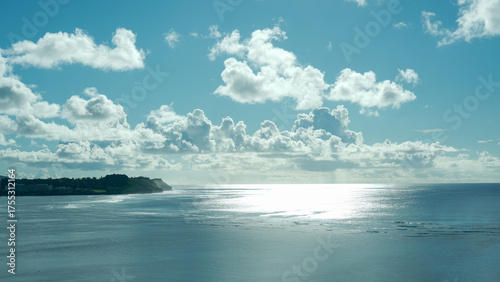“Peaceful tropical coastline under bright sky and clouds in Guam”original