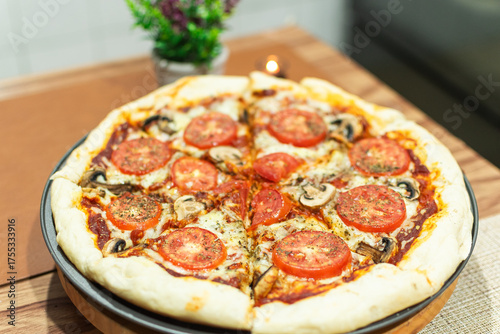 Photograph of freshly baked homemade margarita pizza on a round wooden plate
