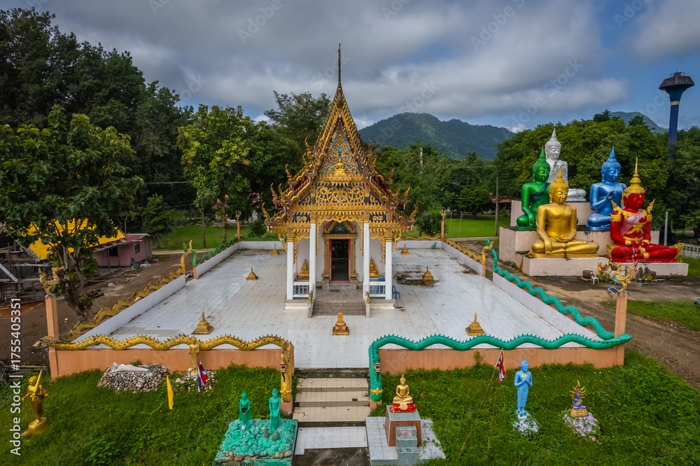 Obraz premium A breathtaking drone view of Wat Hat Ngio Rai surrounded by lush forests and mountains in Sai Yok District, Kanchanaburi, Thailand.