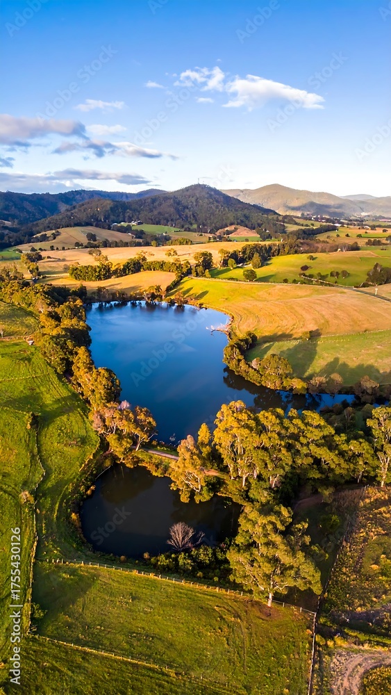 Fototapeta premium Aerial view of a scenic landscape with a lake surrounded by fields