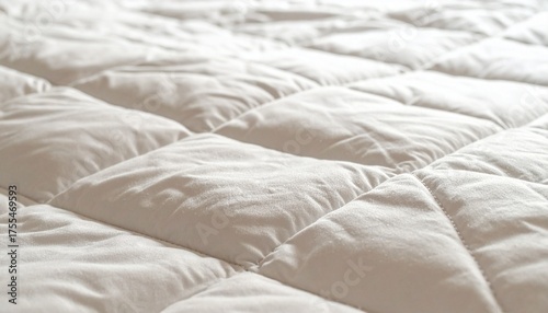 Close up of a soft white quilted mattress topper surface.
