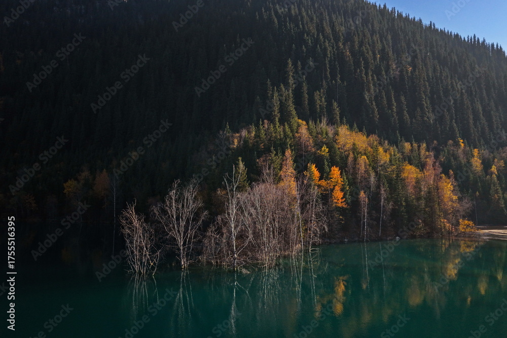 Fototapeta premium Lake Issyk in the rays of the setting sun. National Nature Park. Mountainous area with different vegetation. View from a drone.