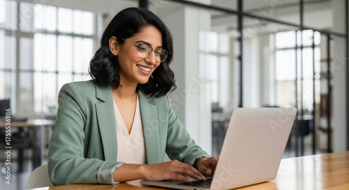 Happy Indian Woman Working on Laptop in Modern Office