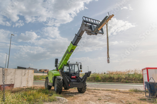 Forklift on a construction site, preparing to raise construction parts