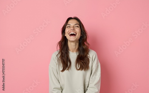 Young laughing woman against pink background. High quality