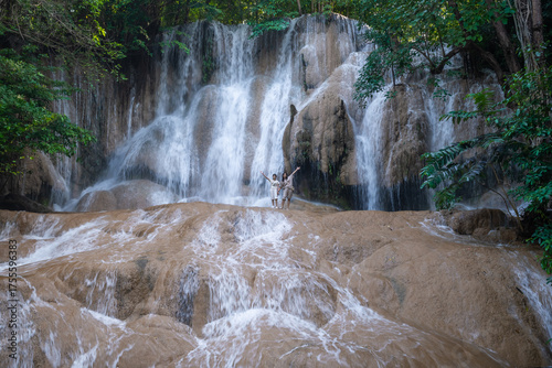 Sai Yok Noi Waterfall in Kanchanaburi, Thailand, is a charming spot surrounded by lush forest, a gentle cascade, peaceful nature, and beautiful scenery.