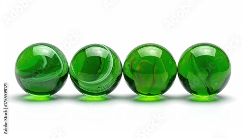 Four green glass marbles lined in a row on white
