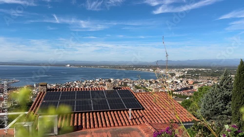 Solar batteries, cell panels or solar electric panels on house roof on Mediterranean sea in Spain. Photovoltaic Solar array system produce clean ecological electricity, Renewable energy. Sea bay view