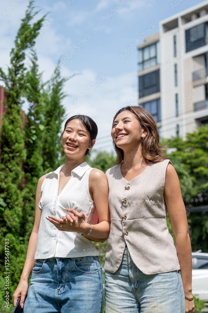 Obraz premium Pretty asian woman couple friends holding hands standing or walking together in hot summer sunlight.