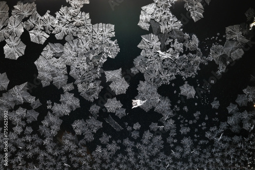 Ice crystals freezing on a black background, abstract winter photo surface