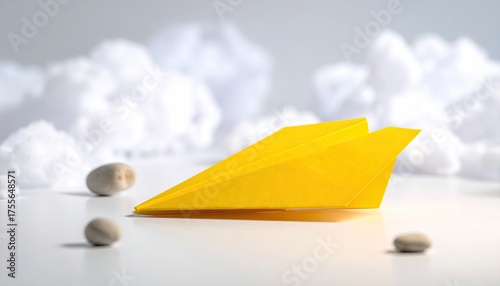 Yellow paper plane on white, cotton clouds background