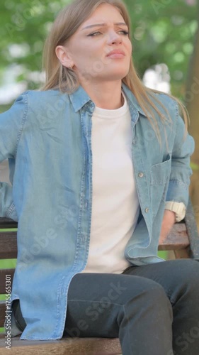 Outdoor Sitting Young Woman with Spinal Injury having Back Pain, Vertical Video