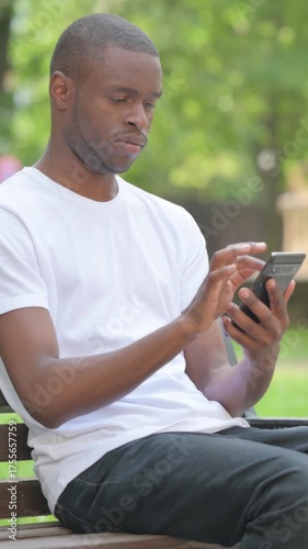 Young African Man Using Smartphone Outdoor in Park, Vertical Video