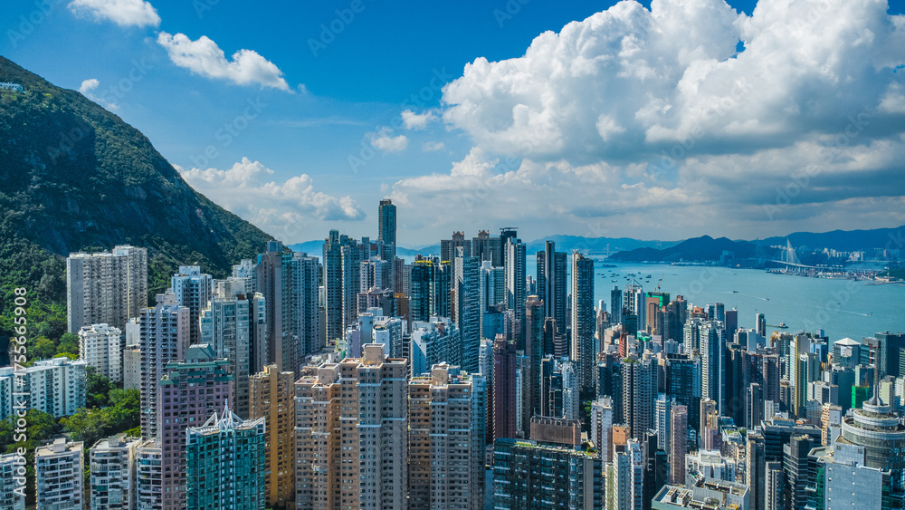 Obraz premium Latest October 2025 aerial view of Hong Kong business skyscrapers, Victoria Harbour, Sheung Wan, Mid Levels and Hong Kong Island in beautiful clean sky and fluffy cloud