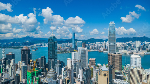 Latest October 2025 aerial view of Hong Kong business skyscrapers, Victoria Harbour, Kowloon and Hong Kong Island in beautiful clean sky and fluffy cloud
