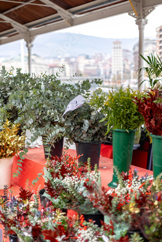 Eucalyptus and festive bouquets at a market stall with a view over the city of Bilbao, Spain. A concept of urban floristry, seasonal trade, and local small business.