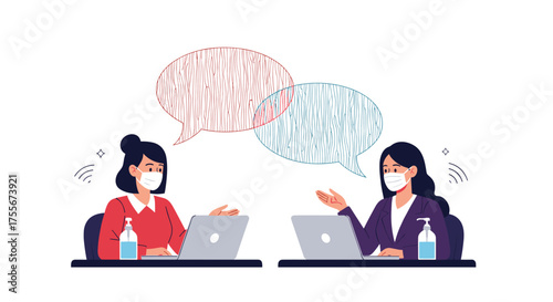 Two women wearing masks and talking while working on laptops with hand sanitizer nearby.