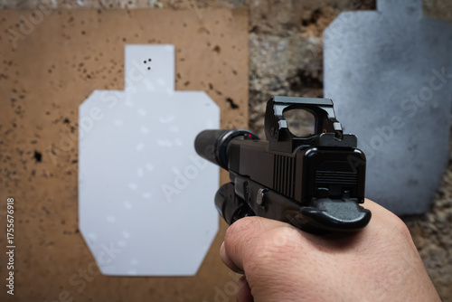Canvastavla First-person view of tactical shooting practice, aiming a modern handgun with a suppressor and red dot sight at a target