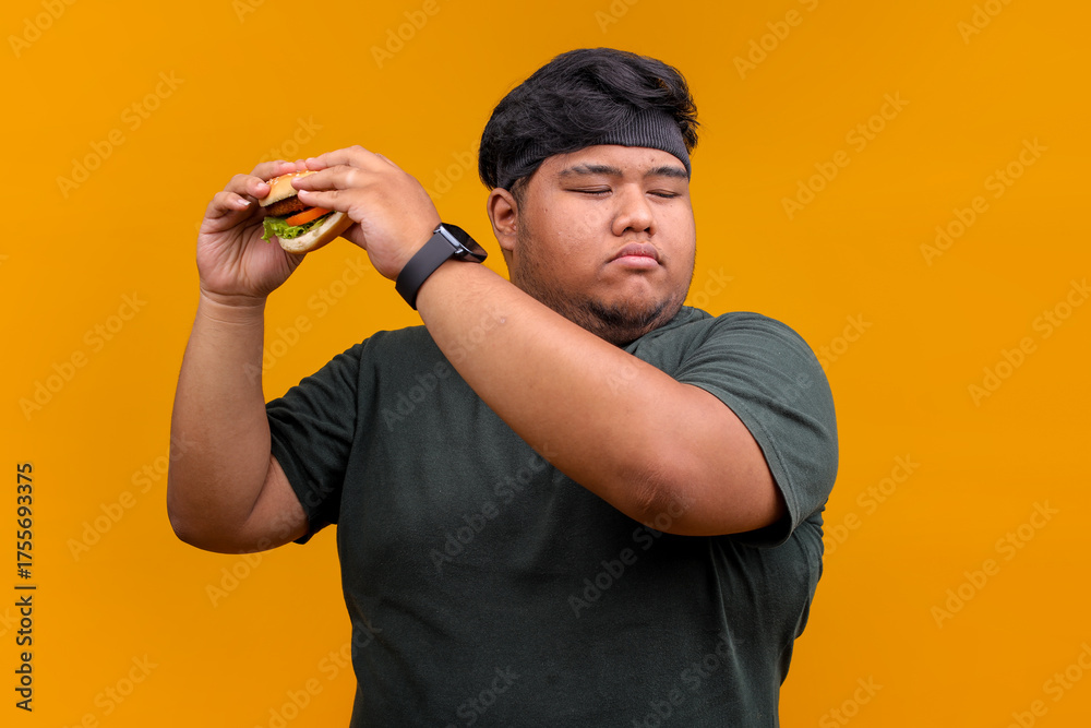Naklejka premium Overweight Man with Eyes Closed About To Eat Burger, Representing Unhealthy Eating Habits and Desire