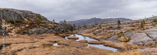 Norwegian nature near Preikestolen, national park in Rogaland, Norway, touristic hiking trail panoramic view, rocks gloomy autumn day and dramatic sky