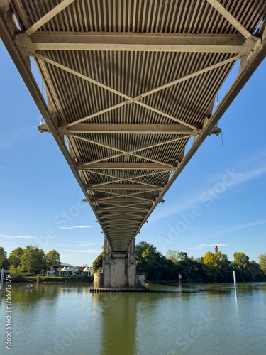 Underneath a Metal Bridge Structure Over a River on a Sunny Day