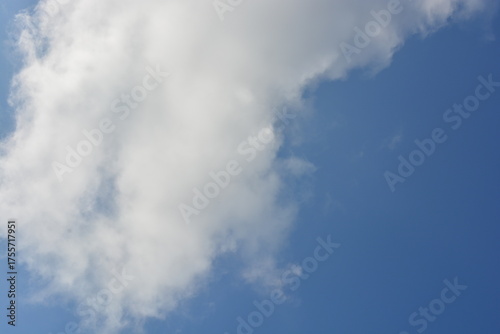 Beautiful and bright unusual nature, gentle autumn blue sky with light white clouds, big cloud, bright sun rays, sunny weather.