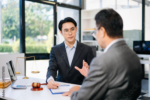 Lawyer advising client on contract signing in modern office, with gavel and scales of justice. Perfect for law, finance, consulting, or business concepts.
