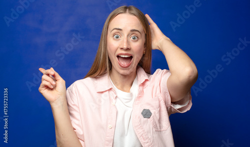 laughing, looking happy, positive and surprised, realizing a great idea pointing to lateral copy space