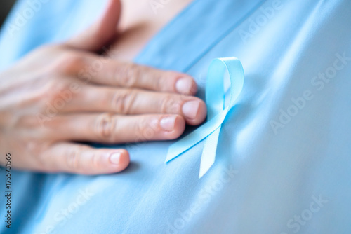 Close up of woman doctor in uniform with blue ribbon on clothes. Prostate cancer awareness month in November, prevention, early diagnosis, and oncology care reminder concept.