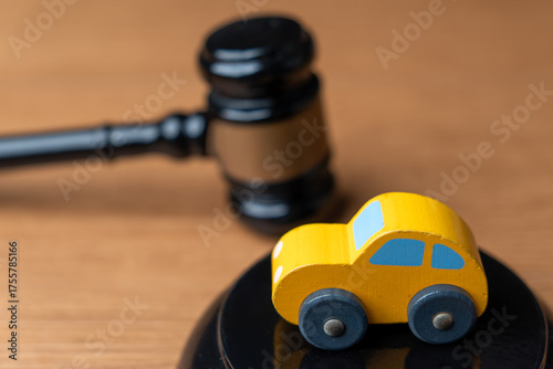 Toy car and a judge’s gavel. Automobile law, insurance claims, legal disputes, traffic court concept.