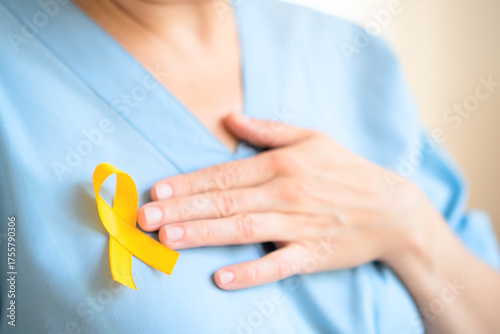 Canvas Print Close up of female doctor and nurse in uniform with yellow ribbon pinned on clothing