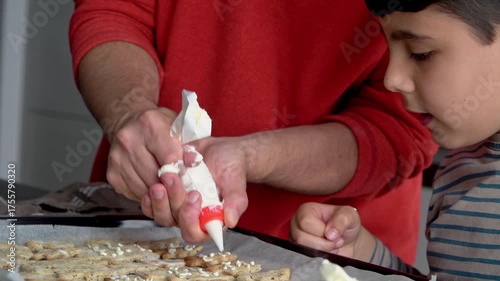 Parent and child enjoying decorating festive tree cookies