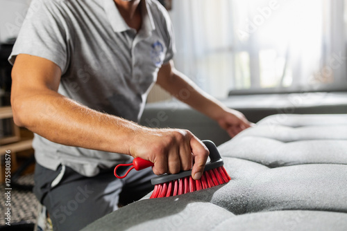 Tableau sur toile Man cleaning gray sofa with upholstery brush