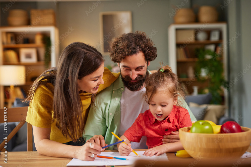 Fototapeta premium A family spends quality time at home, engaging in fun coloring and drawing activities at a table. Parents assist their child who is excitedly creating art.
