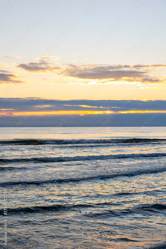Fototapeta premium Vertical view of sea waves at sunrise. Atmosphere of new day.