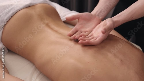 Swedish massage, back therapy, deep tissue. Therapist is seen giving back massage to client in prone position, utilizing therapeutic methods to soothe muscles and relax body.