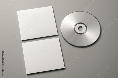 Digital Data Storage: A sleek, reflective CD disc and two accompanying square card are arranged against a clean backdrop, signifying the intersection of physical media and digital data.