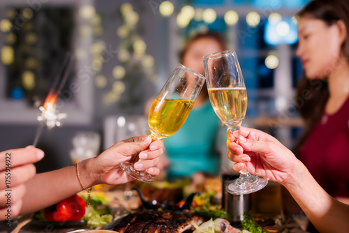 Photos Beautiful woman having fun with group of friends clinking champagne glasses during celebration party