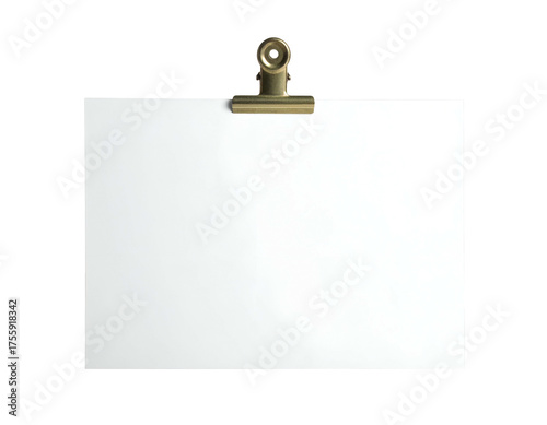 A white sheet of paper held by a gold-colored clip on a black background